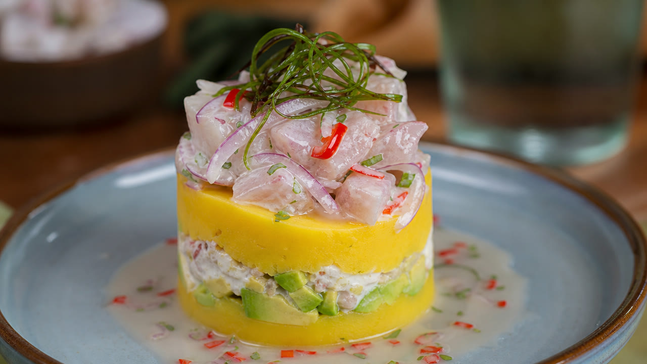 Causa acevichada de papa amarilla con palta y pescado en leche de tigre
